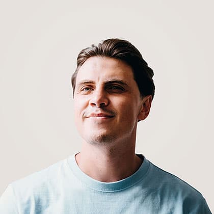 Man in light blue t-shirt against a neutral background.